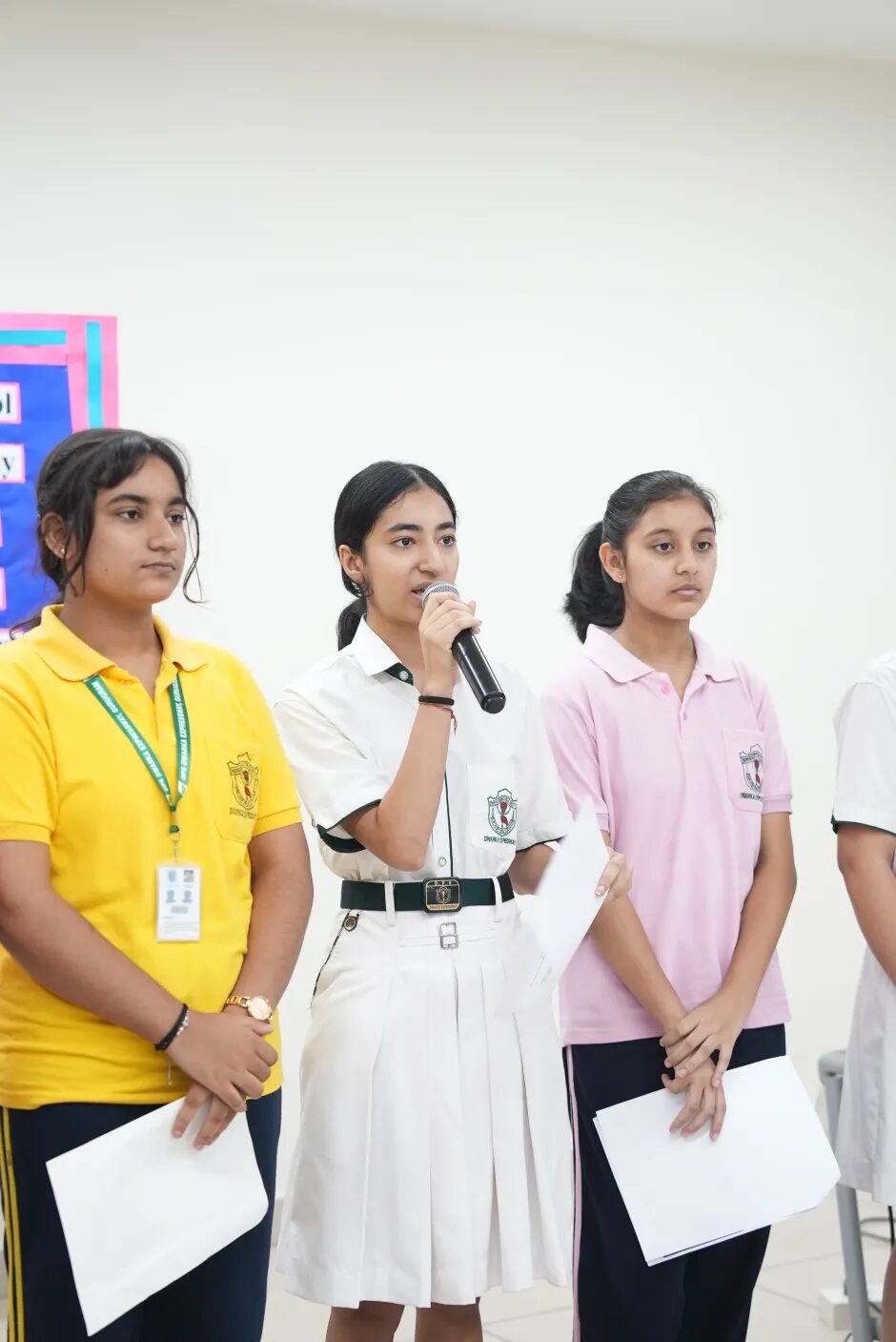 Three students presenting with a microphone