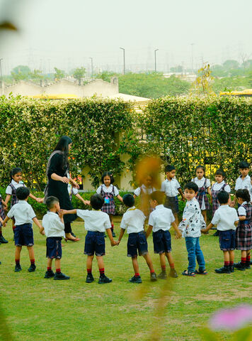 Students standing in a circle on the lawn during an outdoor activity