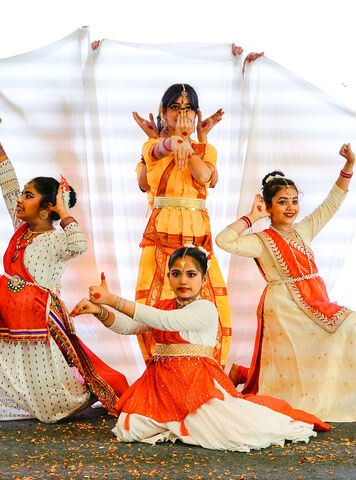 Students performing a classical dance on stage