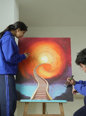 A student painting a canvas at an easel