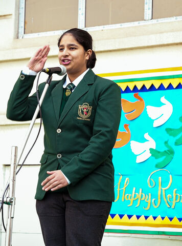 A student in a school blazer saluting at the Republic Day assembly